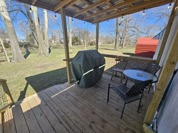 a backyard of a house with barbeque and wooden fence