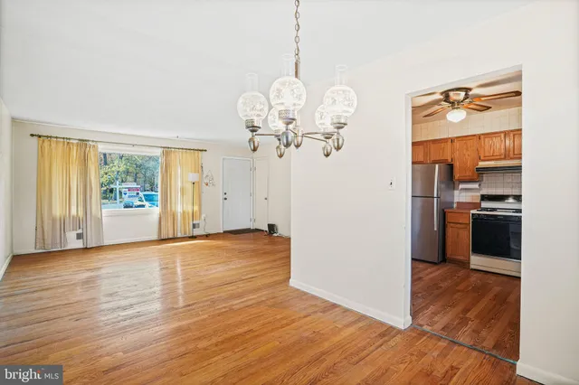 a view of a kitchen with a sink refrigerator and wooden floor