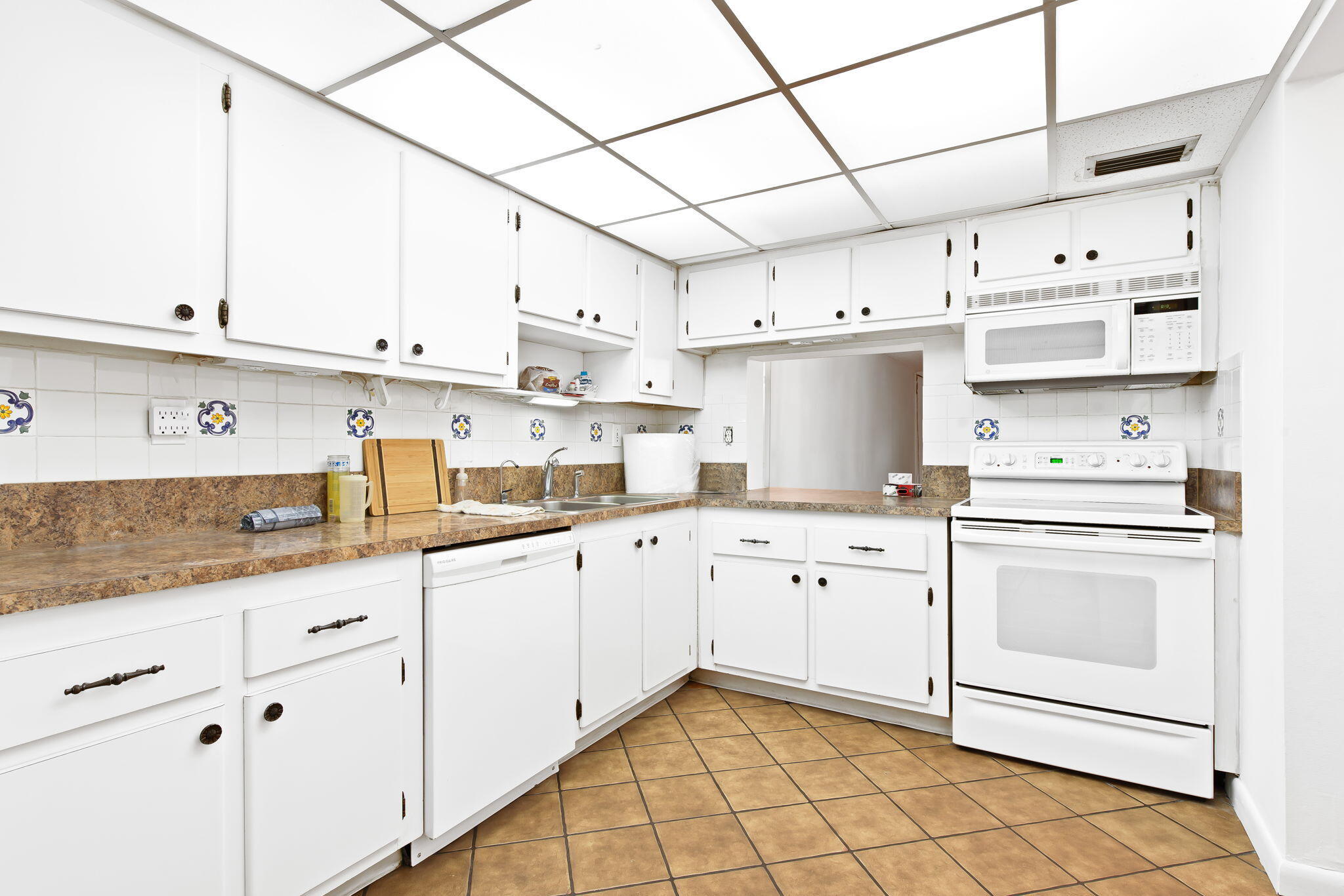 6491 Racquet Club Drive, Unit 36 Lauderhill, FL 33319 - Photo 4 of 24 a kitchen with cabinets window and white appliances