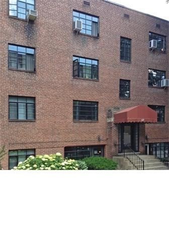 69 A Strathmore Road, Unit 69A Boston, MA 02135 - Photo 2 of 12 a black and white building with a yard in front