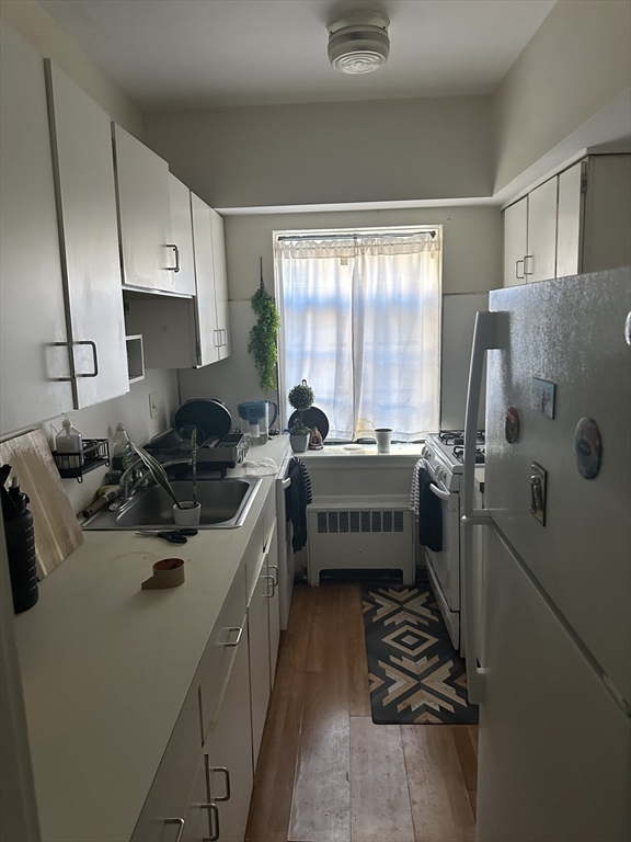 69 A Strathmore Road, Unit 69A Boston, MA 02135 - Photo 8 of 12 a kitchen with a sink appliances and cabinets