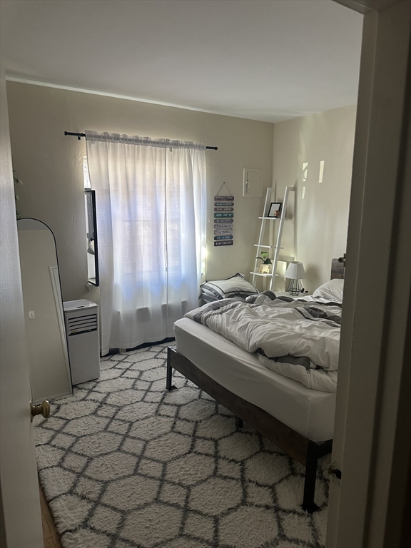 69 A Strathmore Road, Unit 69A Boston, MA 02135 - Photo 9 of 12 a bedroom with a bed and a chair