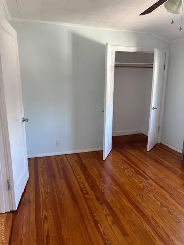 an empty room with wooden floor and closet