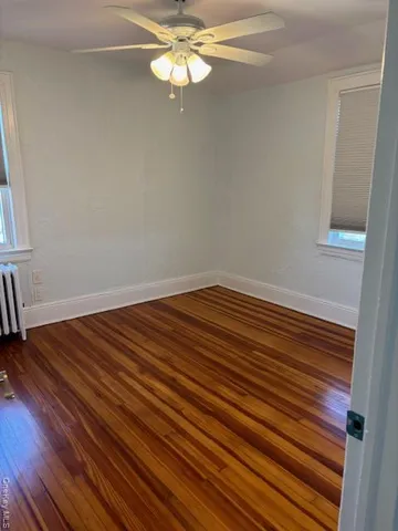 a view of a room with wooden floor and fan
