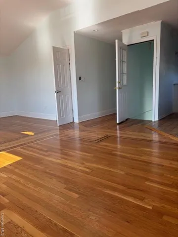 an empty room with wooden floor and closet