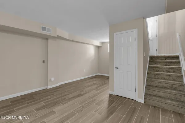 a view of an empty room with wooden floor and entryway