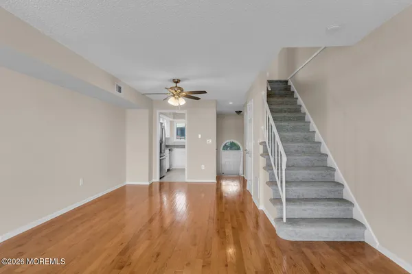 a view of a room with wooden floor and staircase