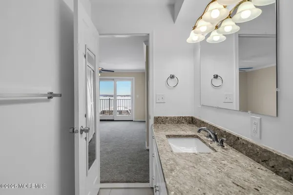 a bathroom with a sink a light fixture and a mirror
