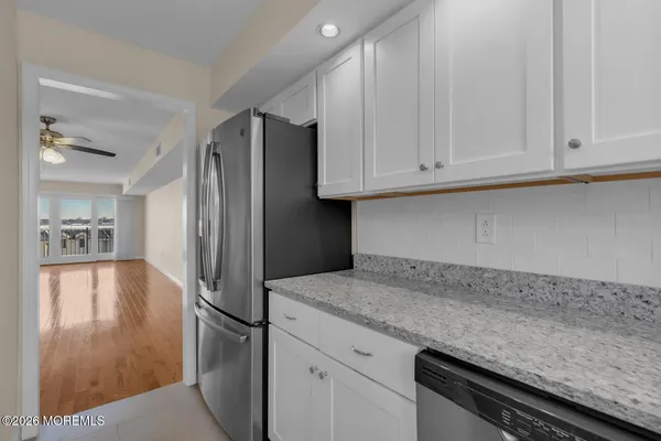 a kitchen with granite countertop stainless steel appliances and refrigerator