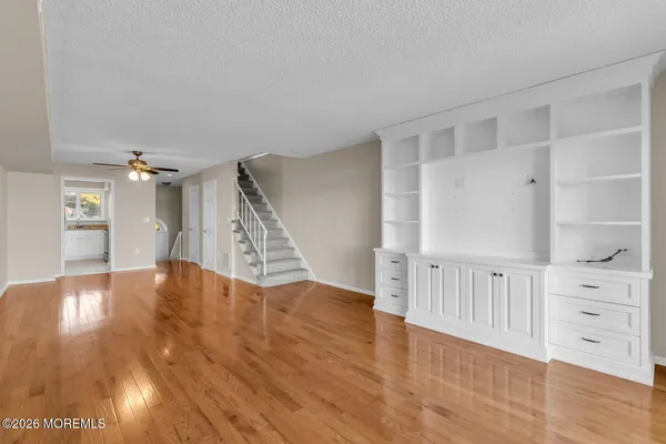 a view of an empty room with wooden floor and a cabinet