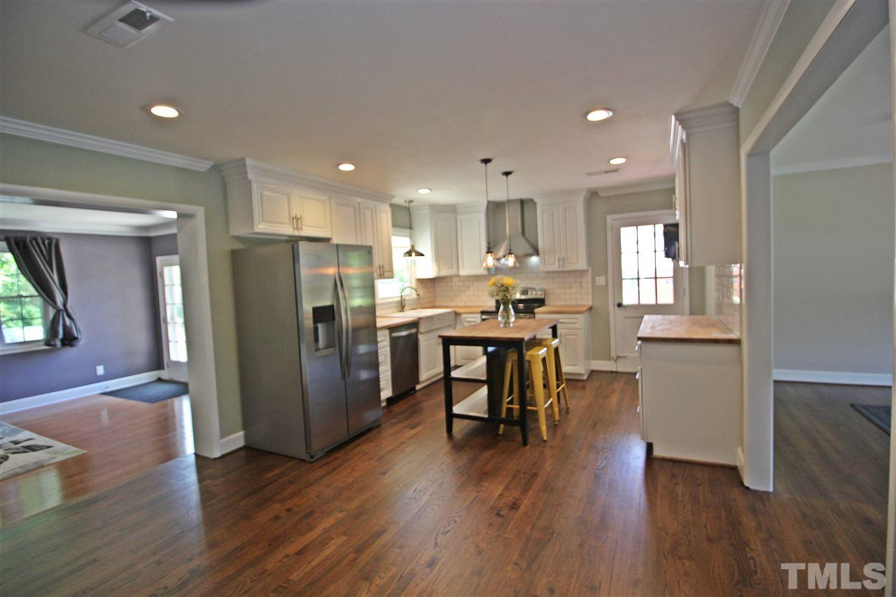2449 Milburnie Road Raleigh, NC 27610 - Photo 5 of 25 a kitchen with stainless steel appliances wooden floors and refrigerator