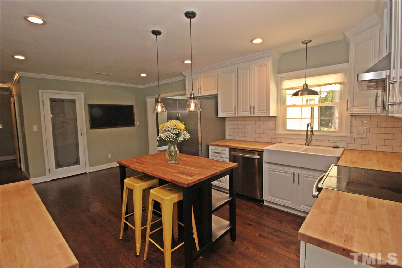 2449 Milburnie Road Raleigh, NC 27610 - Photo 8 of 25 a kitchen with a table chairs sink and microwave