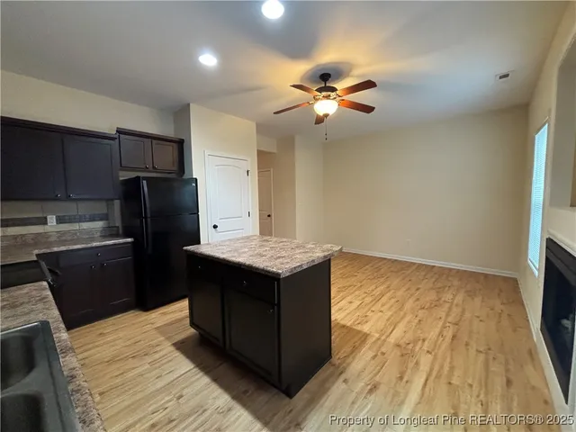a kitchen with a wooden floor and a refrigerator