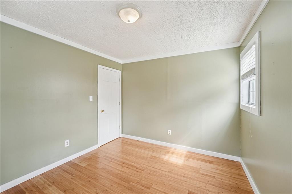 257 Shellhorse Road Southeast Ranger, GA 30734 - Photo 22 of 44 an empty room with wooden floor and windows