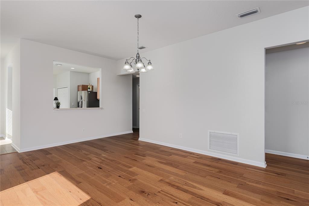 9822 50th St Circle East Parrish, FL 34219 - Photo 15 of 46 a view of a room with wooden floor and chandelier