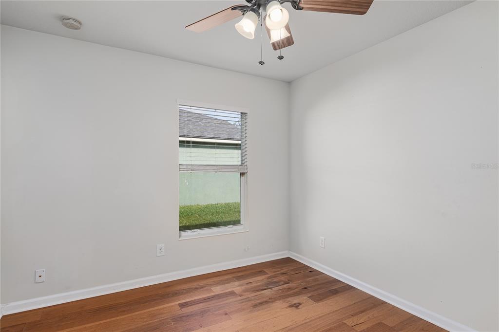 9822 50th St Circle East Parrish, FL 34219 - Photo 20 of 46 a view of an empty room with wooden floor and a window