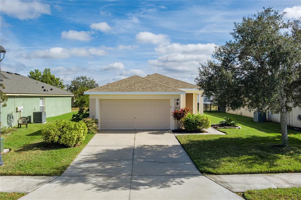 9822 50th St Circle East Parrish, FL 34219 - Photo 26 of 46 a front view of a house with a yard and garage