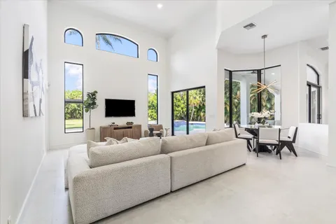 a living room with furniture flat screen tv and a large window