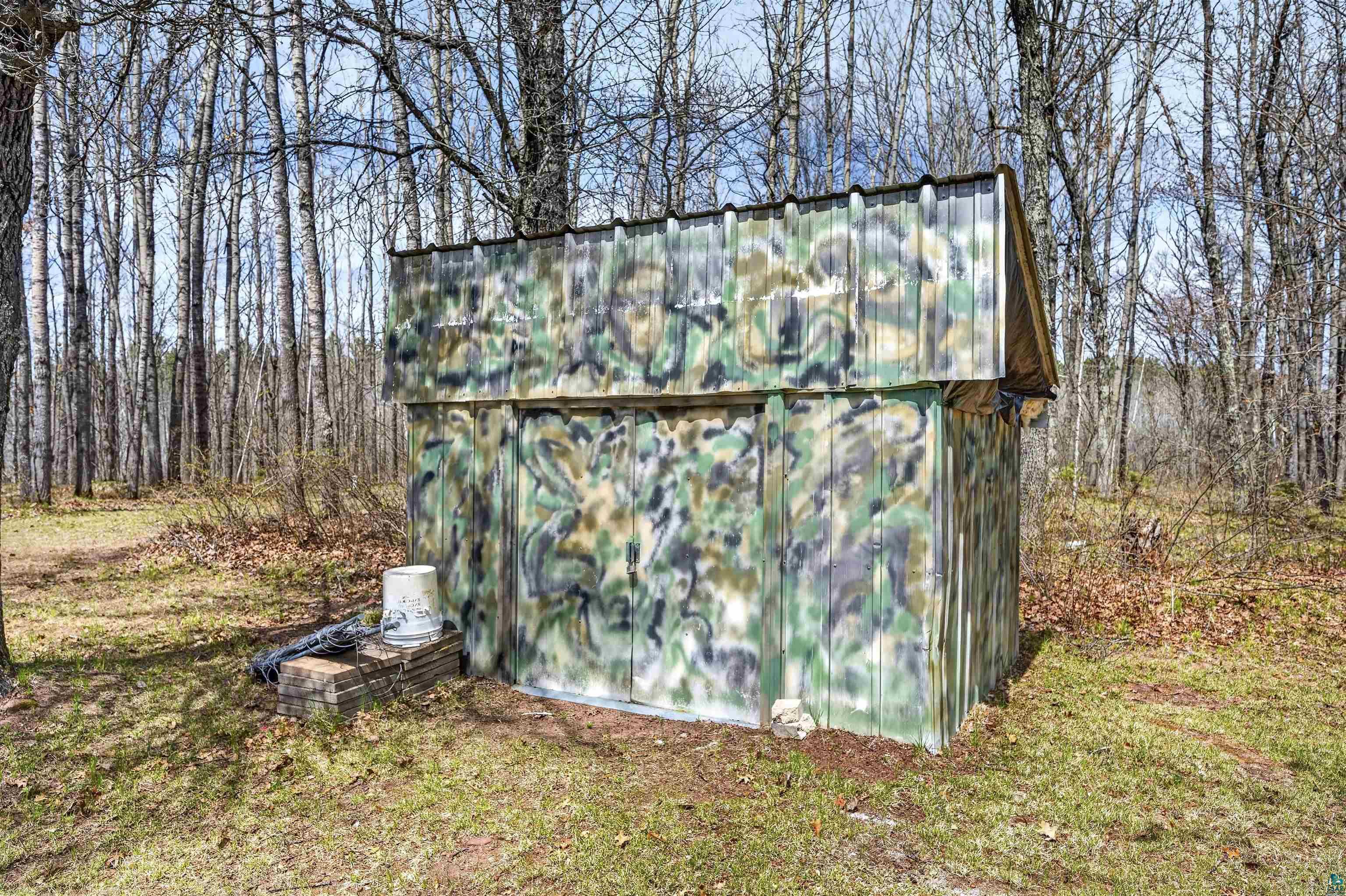 12235 East Crooked Lake Road Gordon, WI 54838 - Photo 38 of 48 Camouflaged storage structure with a metal roof surrounded by mature trees