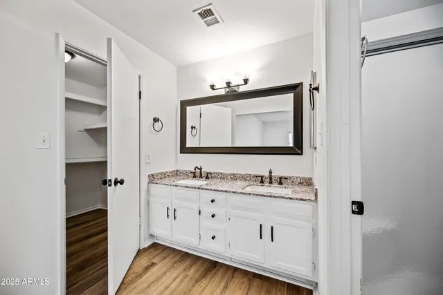 a bathroom with a double vanity sink and mirror