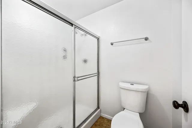 a bathroom with a toilet and a shower