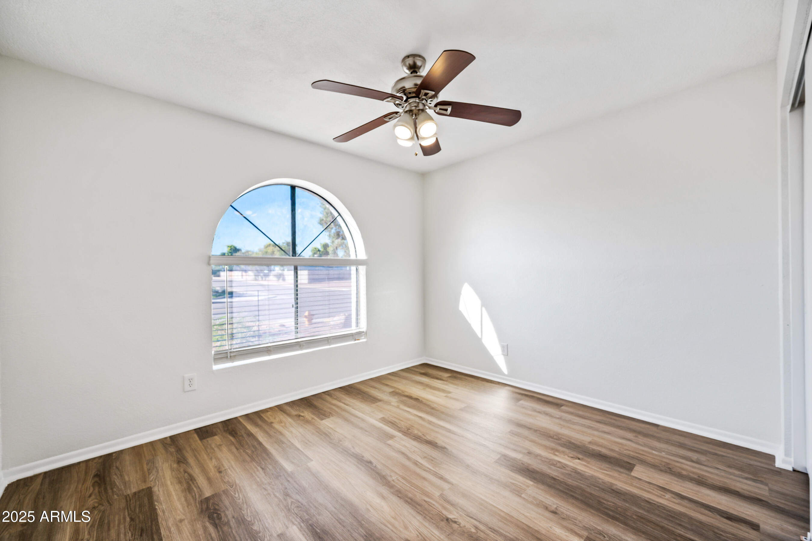2211 North Bullmoose Drive Chandler, AZ 85224 - Photo 17 of 23 an empty room with wooden floor fan and windows