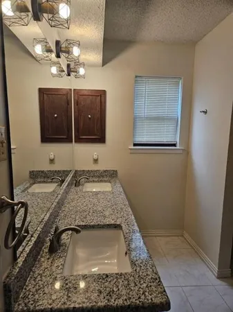 a bathroom with a granite countertop sink a mirror and vanity