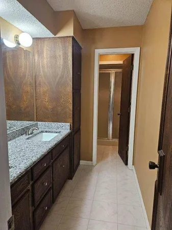 a bathroom with a granite countertop sink and a mirror
