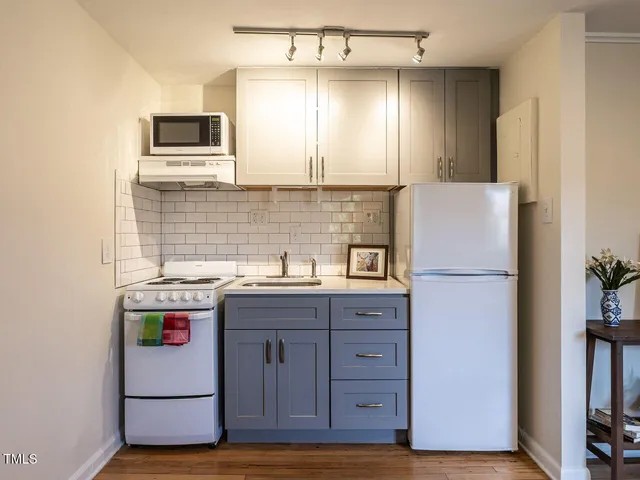 a kitchen with stainless steel appliances granite countertop a refrigerator a stove a sink and a microwave