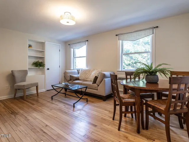 a living room with furniture a table and a potted plant