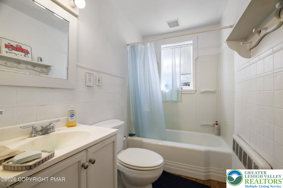 1207 Seese Hill Road Canadensis, PA 18325 - Photo 15 of 49 Classic white wall tiling coordinates beautifully with a traditional vanity and alcove tub setup.