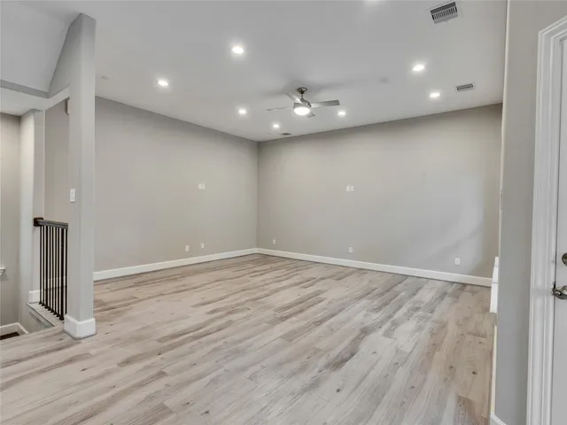 an empty room with wooden floor and entrance