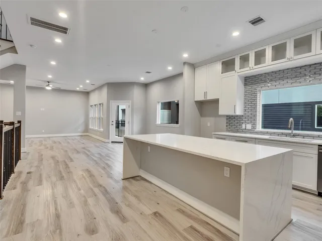 a large kitchen with kitchen island a sink stainless steel appliances and cabinets