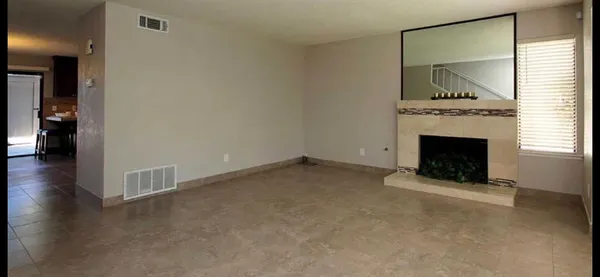 an empty room with a fireplace and wooden floor