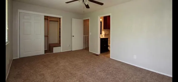 a view of a livingroom with a ceiling fan & entryway