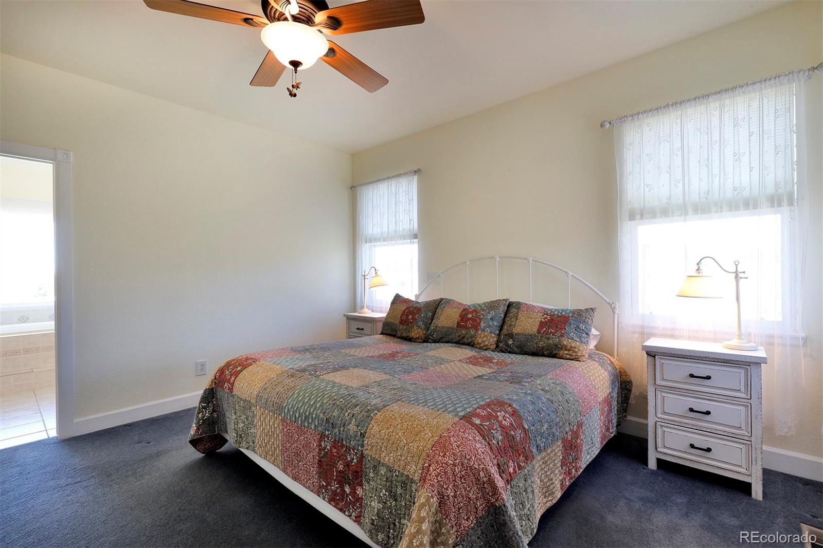 4627 Bayou Hills Road Parker, CO 80134 - Photo 14 of 40 a bedroom with a bed a window and a dresser