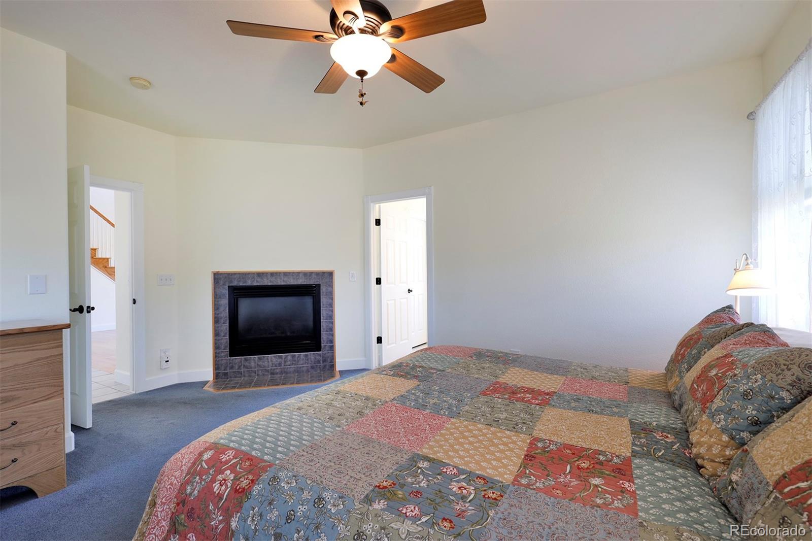4627 Bayou Hills Road Parker, CO 80134 - Photo 15 of 40 a bedroom with a bed and a chandelier
