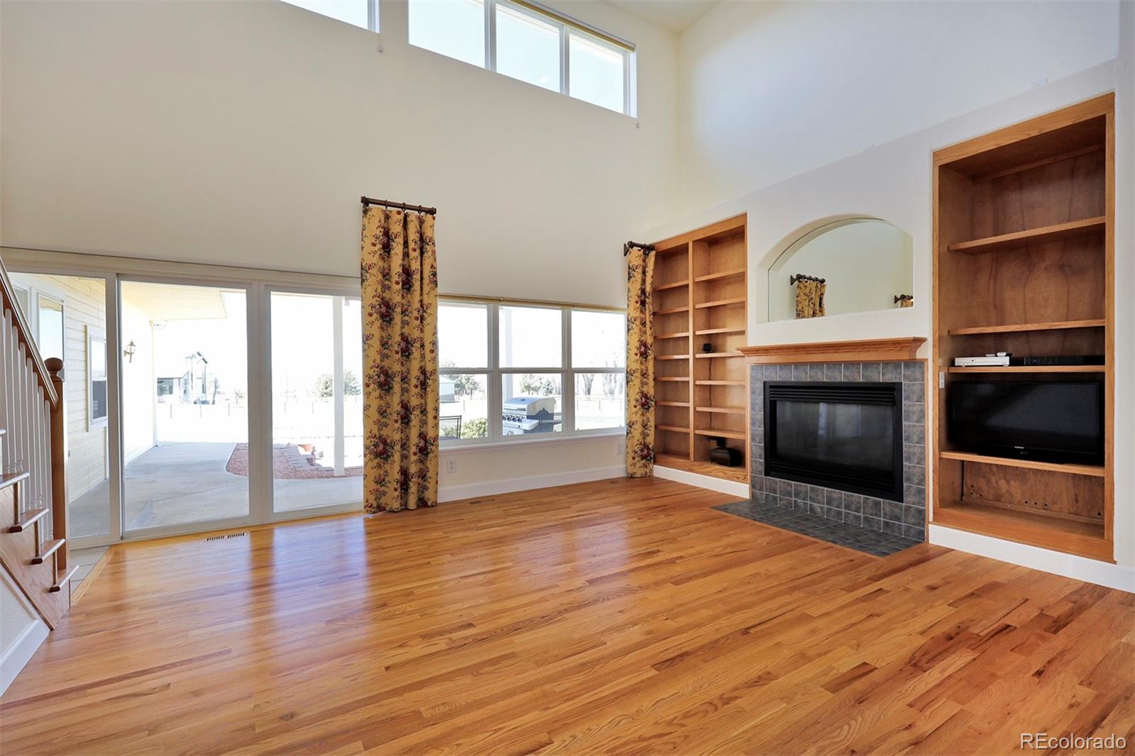 4627 Bayou Hills Road Parker, CO 80134 - Photo 5 of 40 a view of an empty room with wooden floor fireplace and a window