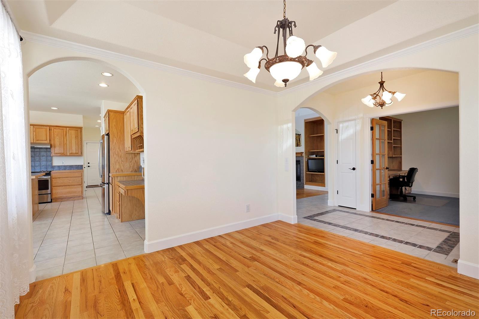 4627 Bayou Hills Road Parker, CO 80134 - Photo 7 of 40 a bedroom with a bed and a chandelier