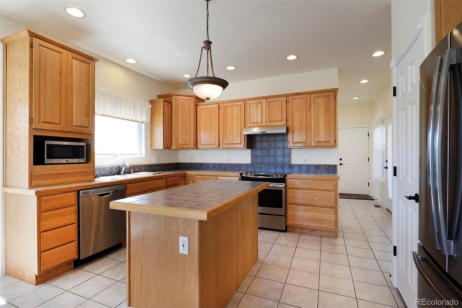 4627 Bayou Hills Road Parker, CO 80134 - Photo 9 of 40 a kitchen with stainless steel appliances granite countertop a stove a sink and a refrigerator