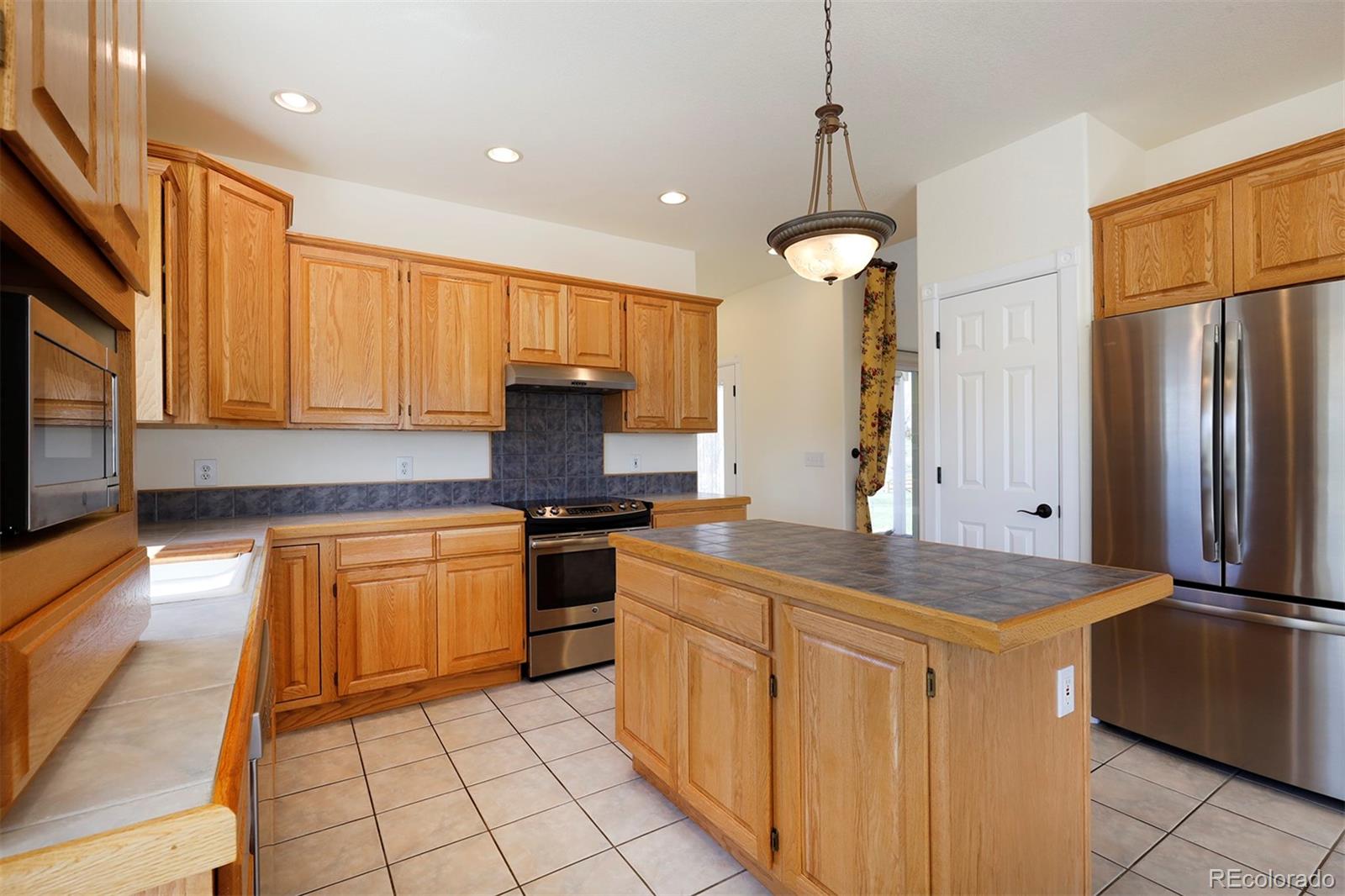 4627 Bayou Hills Road Parker, CO 80134 - Photo 10 of 40 a kitchen with stainless steel appliances granite countertop a stove a sink and a refrigerator