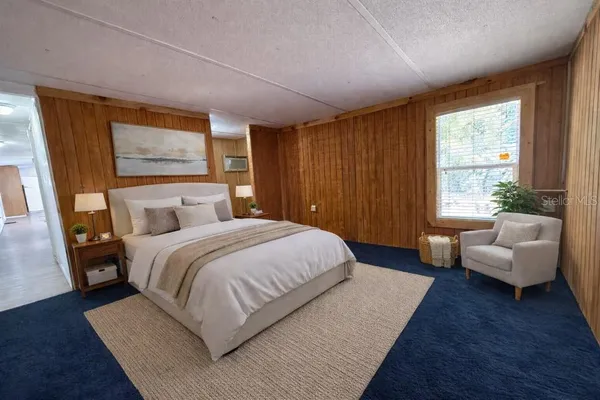 a bedroom with bed couch and window