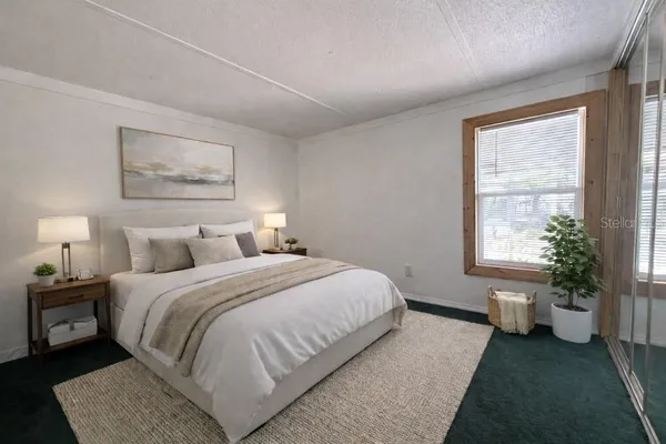 a bedroom with a bed and a potted plant