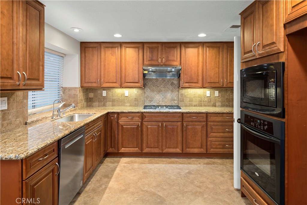 12 Rapallo Irvine, CA 92614 - Photo 10 of 21 a kitchen with kitchen island granite countertop a stove sink and cabinets