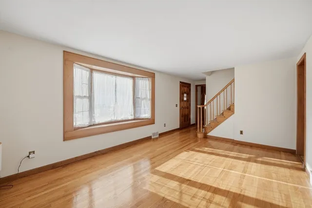 a view of empty room with wooden floor and fireplace