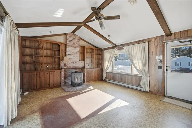 a large kitchen with kitchen island granite countertop a large window cabinets a sink and stainless steel appliances