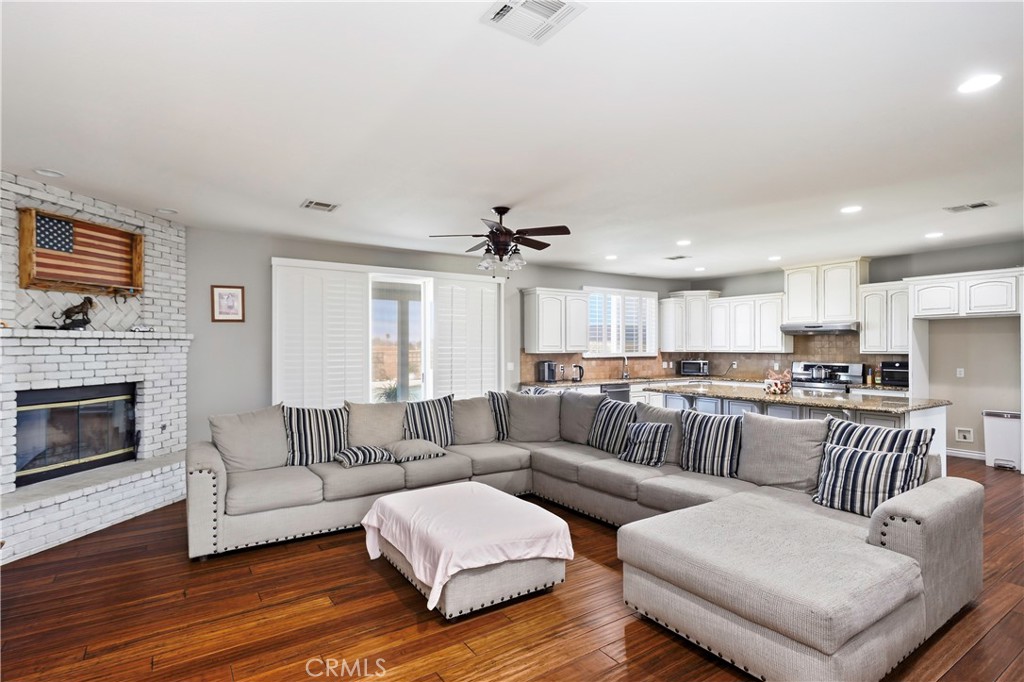 42561 25th Street West Lancaster, CA 93536 - Photo 13 of 41 a living room with furniture kitchen view and a fireplace