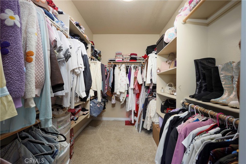 42561 25th Street West Lancaster, CA 93536 - Photo 21 of 41 a view of walk in closet with clothes and shoes