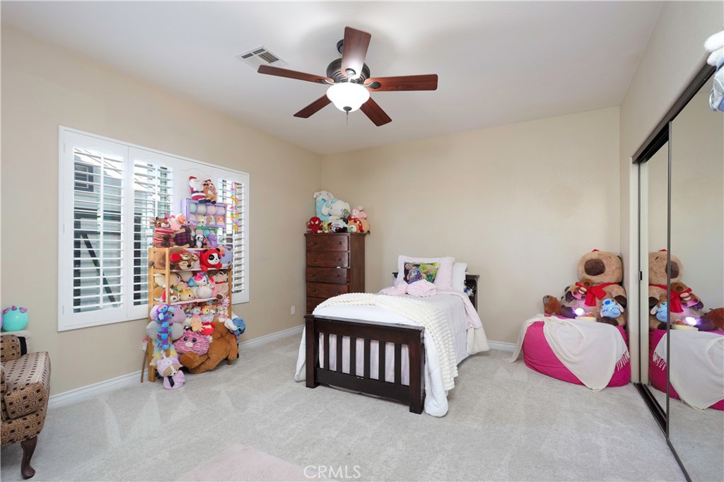 42561 25th Street West Lancaster, CA 93536 - Photo 23 of 41 a bedroom with a bed and a chandelier