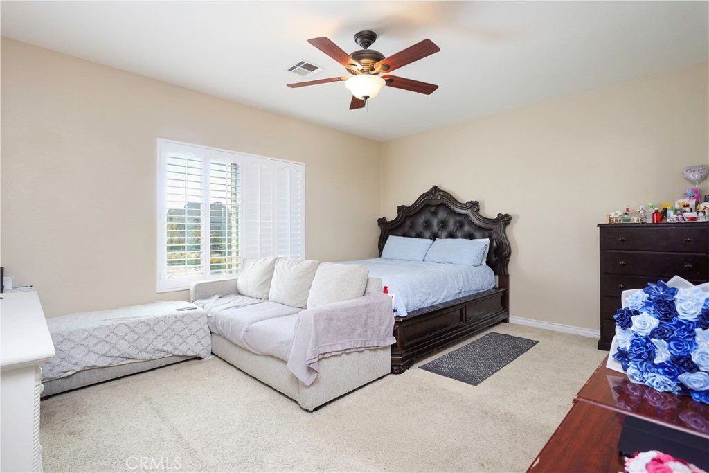 42561 25th Street West Lancaster, CA 93536 - Photo 25 of 41 a spacious bedroom with a bed and a chandelier